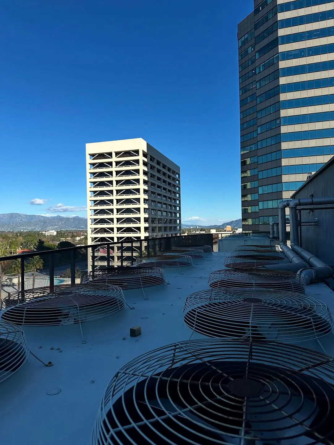 Rooftop condenser fans with Los Angeles area buildings in the background